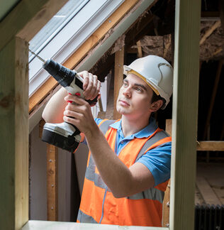 construction worker using drill to install replacement window